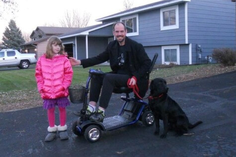 Bobb in his scooter with his daughter and service dog